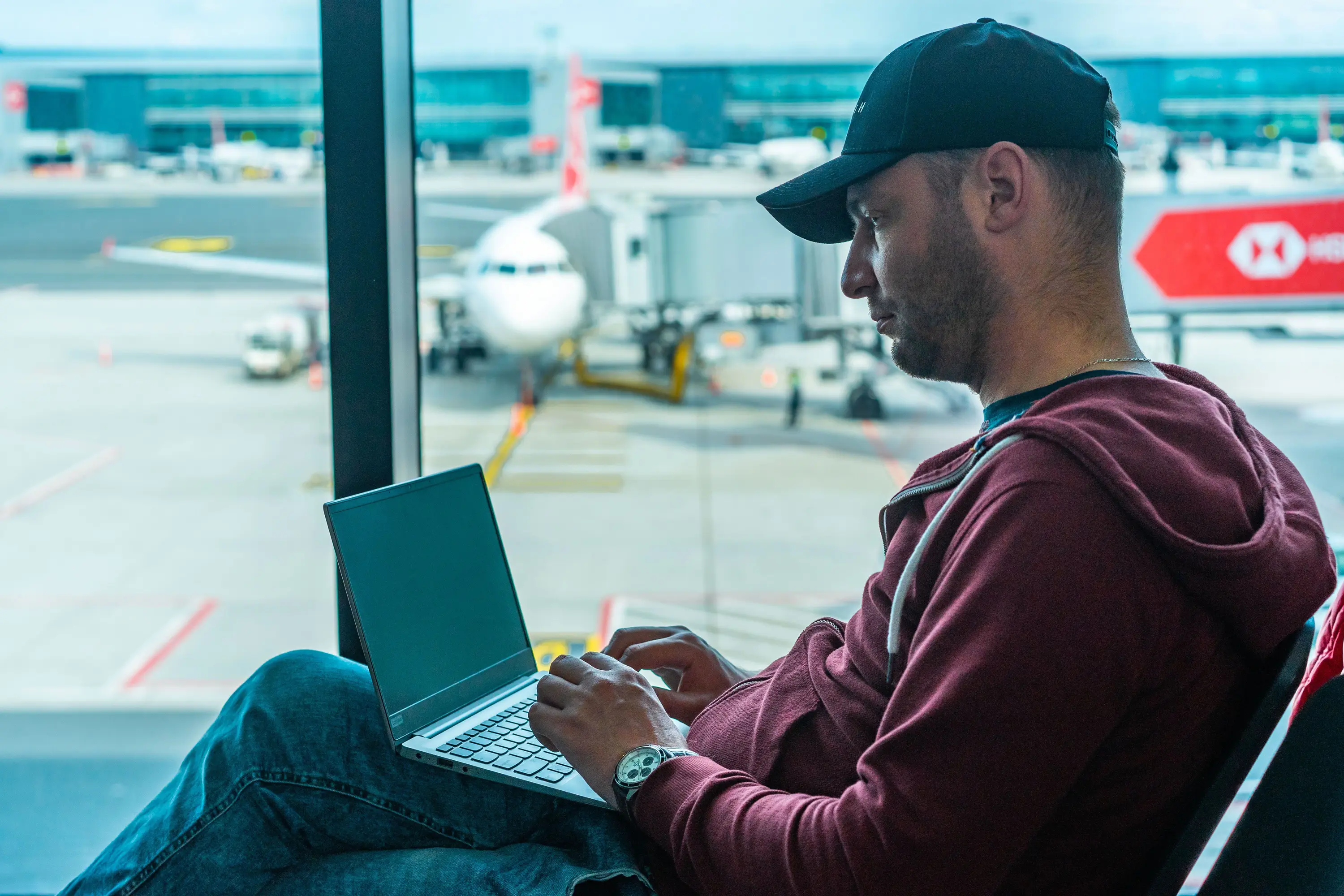 a guy working on his laptop in an airport terminal