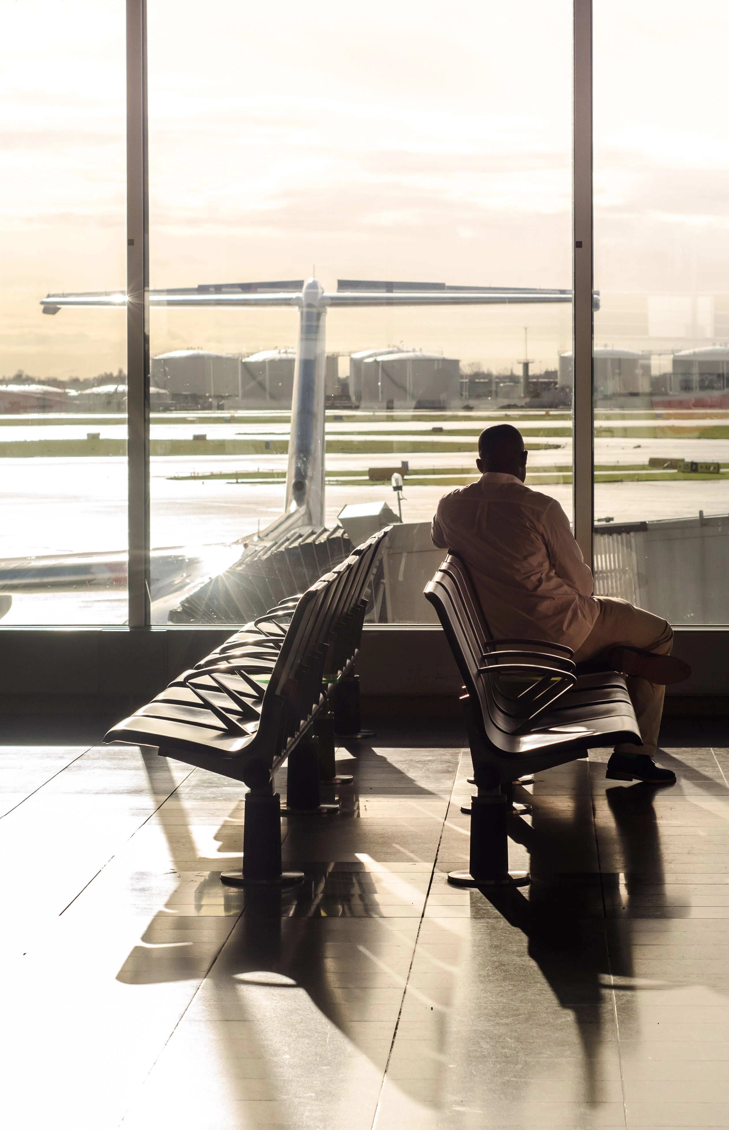 a man sits in an airport terminal after missing connecting flight because of standy