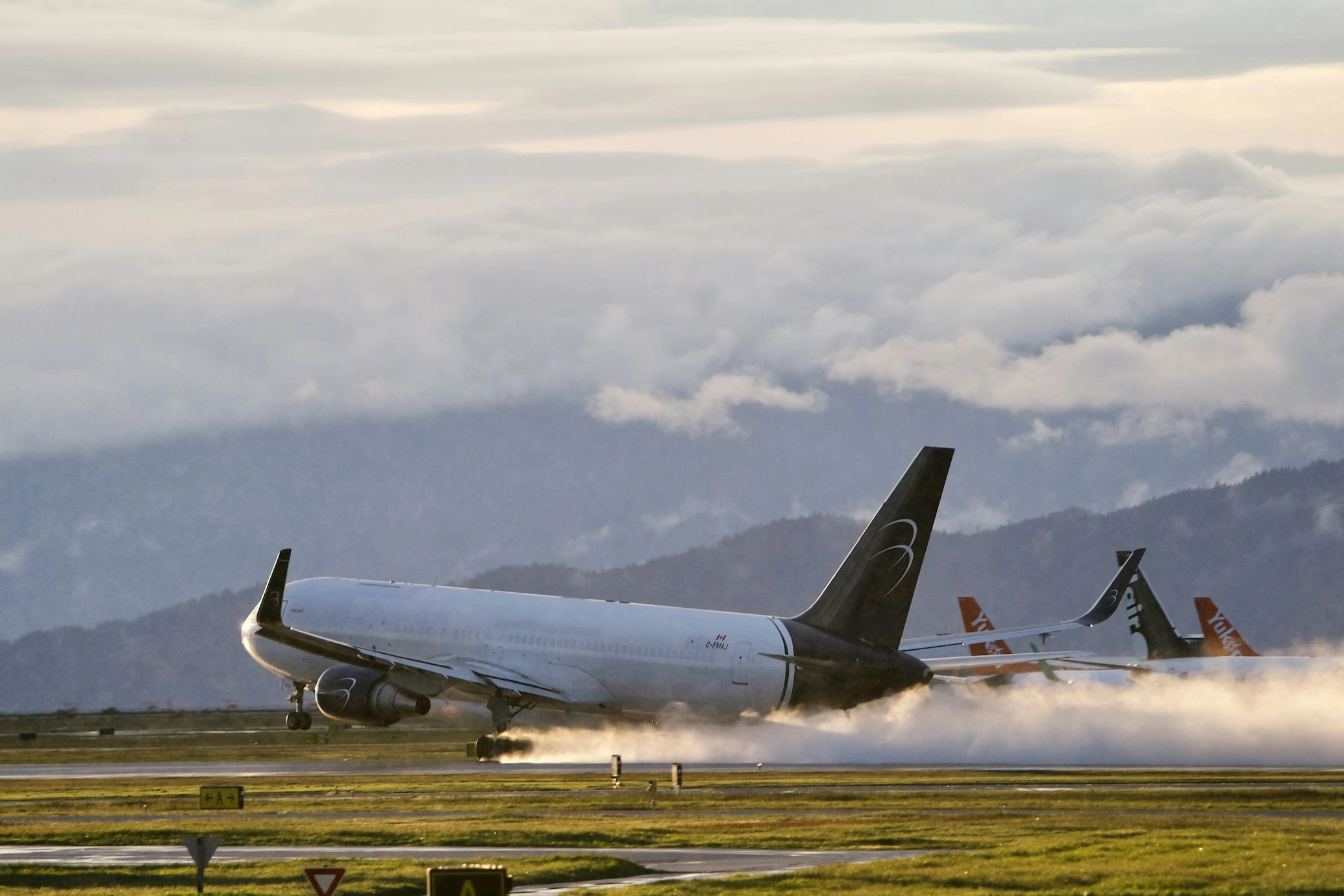 Blue Panorama B767-300ERSF Taking off with contrast between golden water vapor and sky