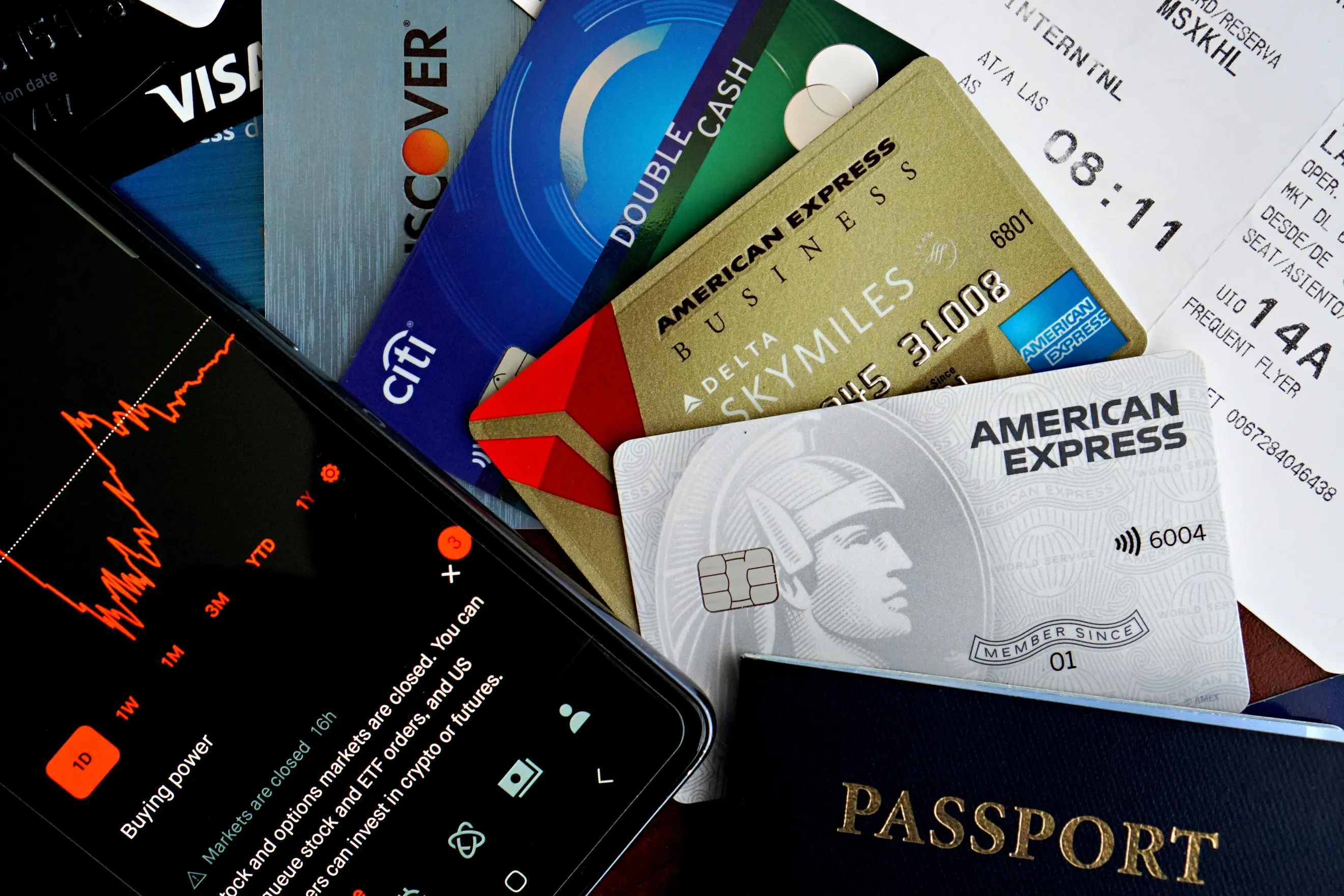 credit cards passport and a phone showing stock data depicting finance and travel