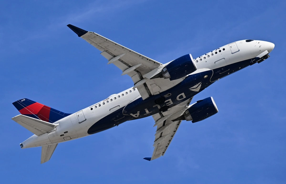 Delta airlines airbus A220 widebody aircraft flying in the blue sky