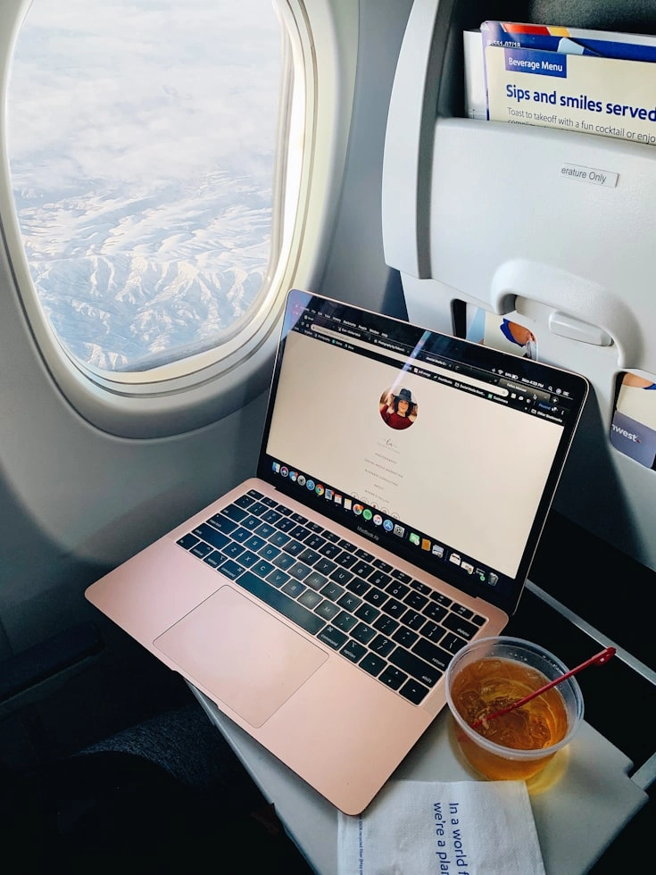 frequent business traveler working beside the airplane window in a business class seat