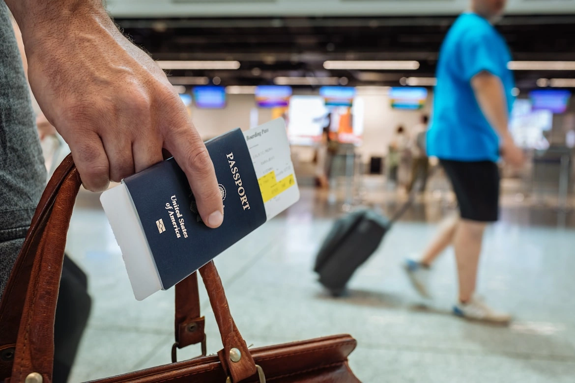frequent traveler holding a credit card and passports of usa at airport terminal
