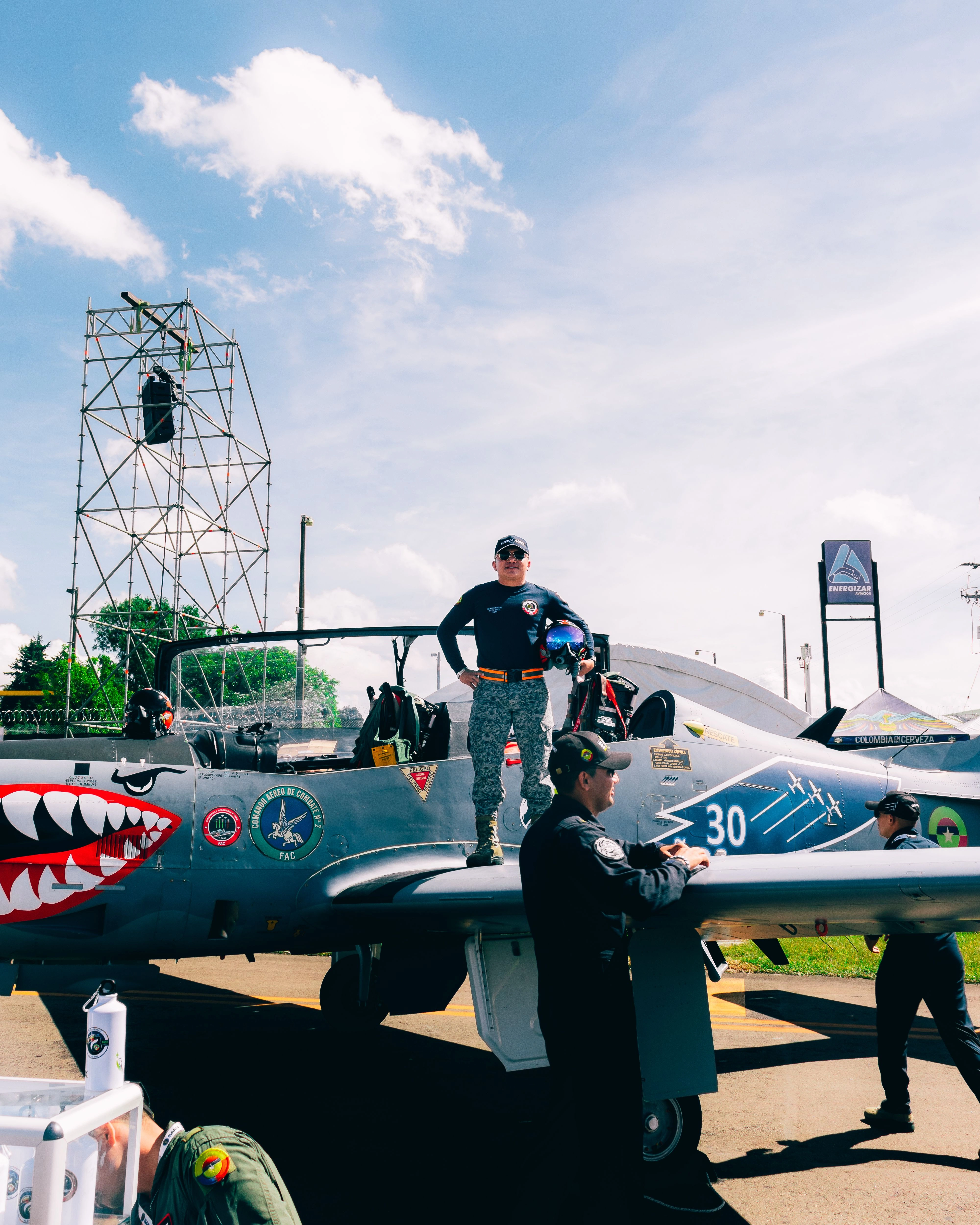 military pilots standing on the decorated fighter jet at on outdoor airshow