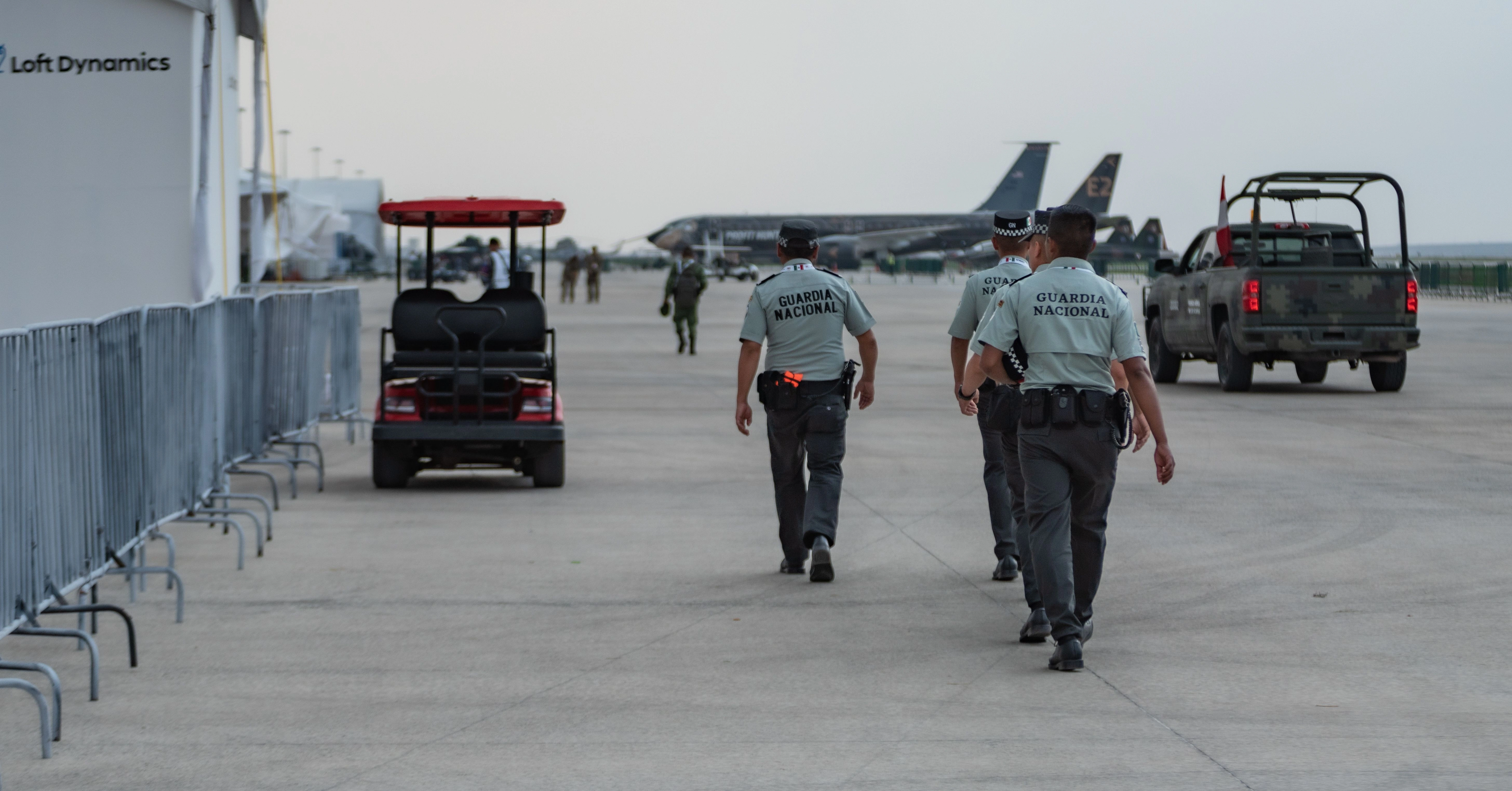 national guard officers patrol military airport featuring aircraft