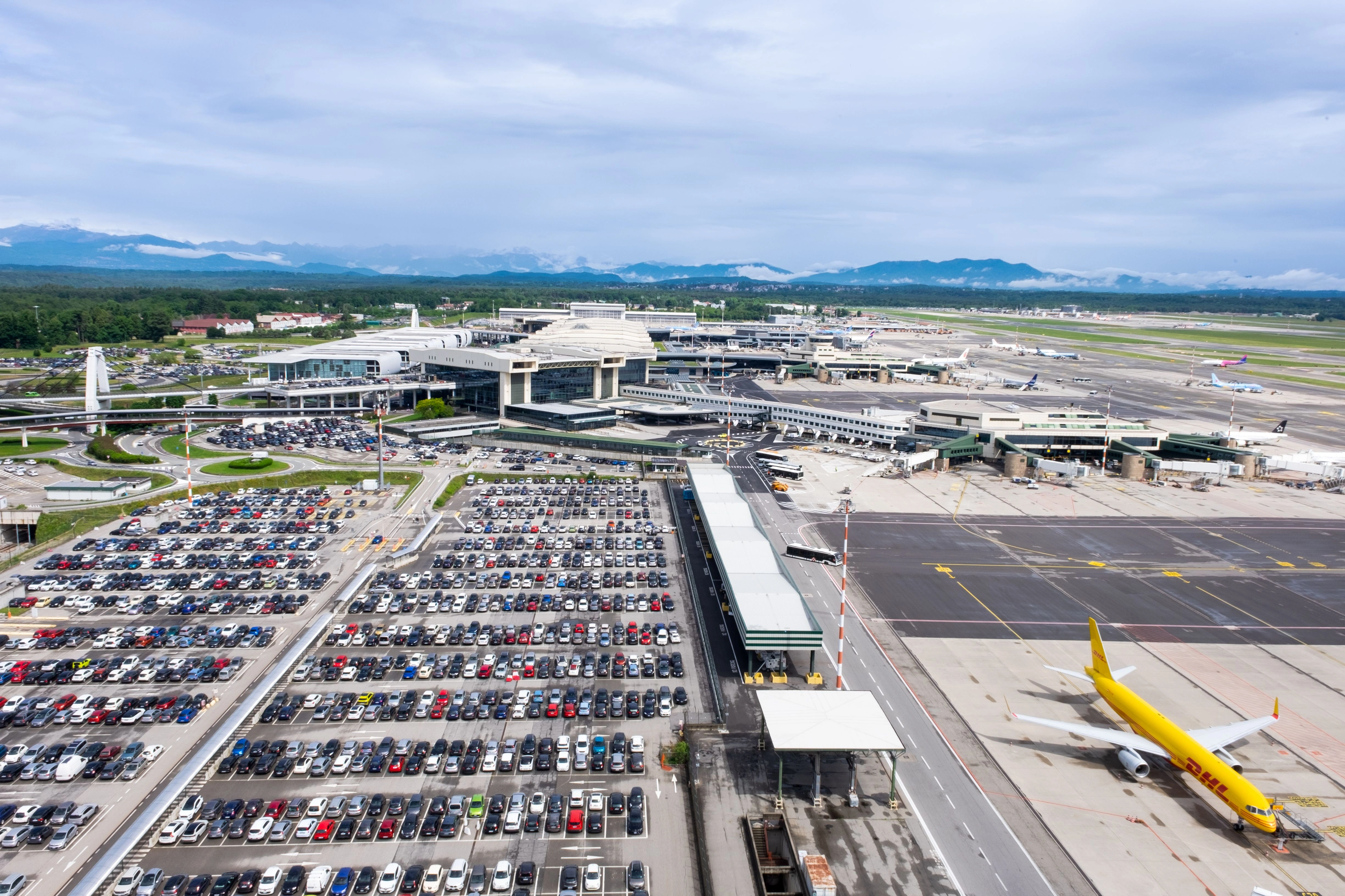 parking of vehincles at the airport showing the multiple vehicle parking and runway in same snap