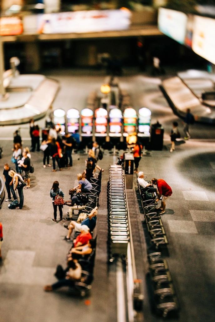 Passenger like frequent flyers and business travelers walking through an airport terminal past a departures board