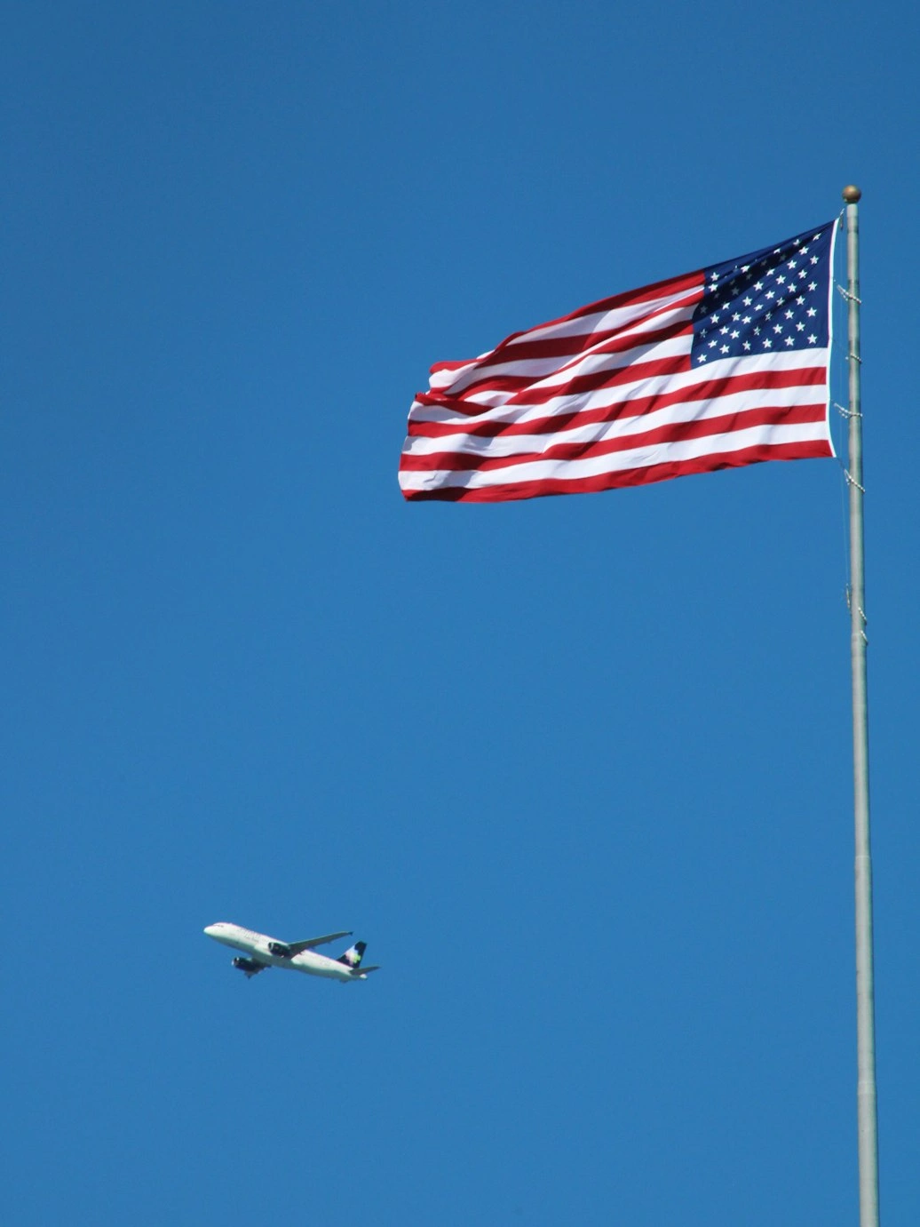 Photo of a US flag with an airplane in the background in miami plane spotting place