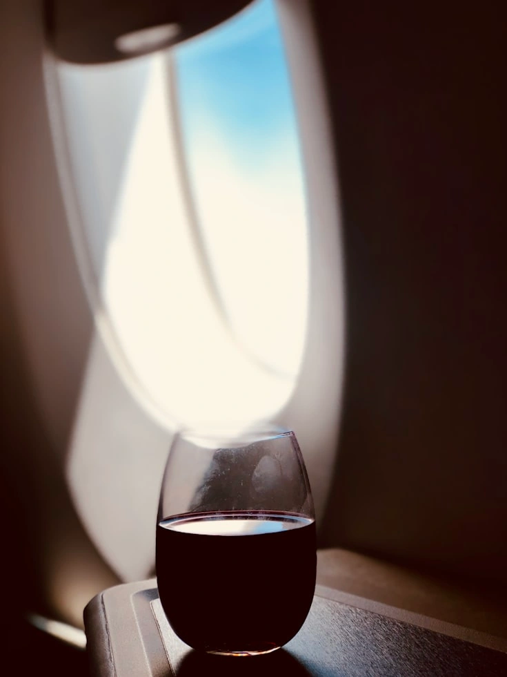 red wine glass beside the airplane window