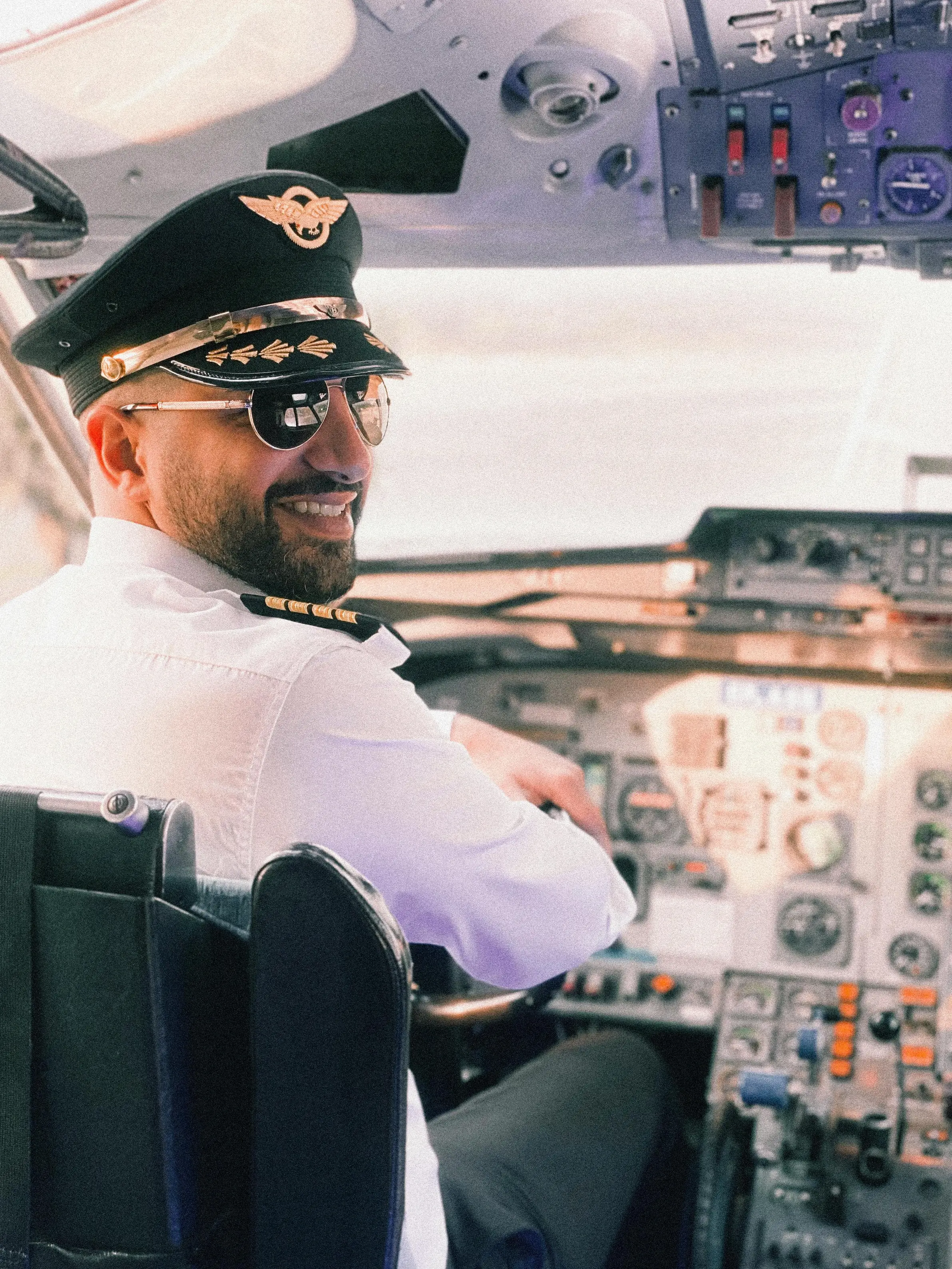 smiling pilot in cockpit at commercial aircraft