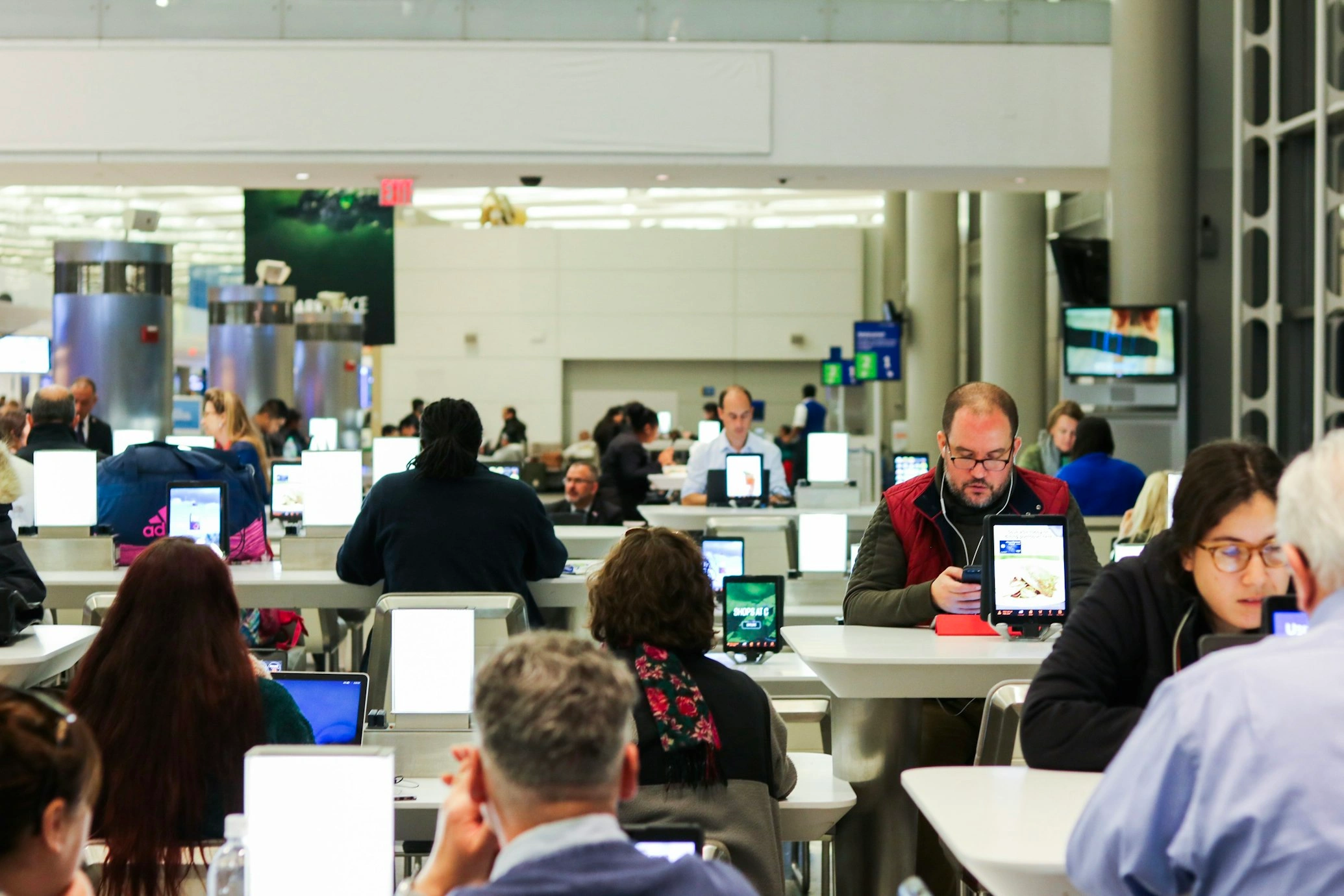 travelers-wtih-devices-at-cafeteria-in-newark-airport