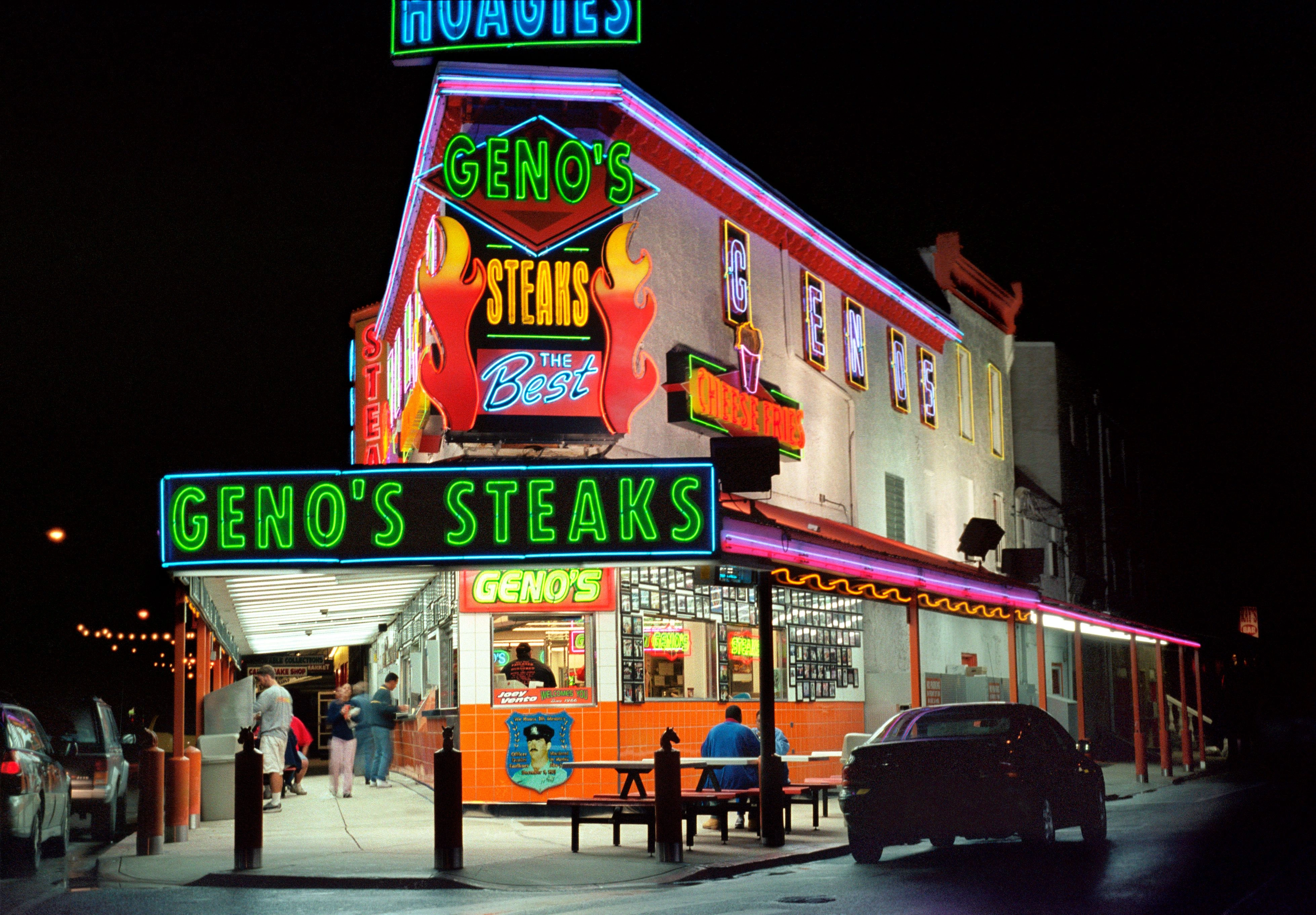 Vibrant neon lit facade of Geno's Cheesesteaks in Philadelphia at night